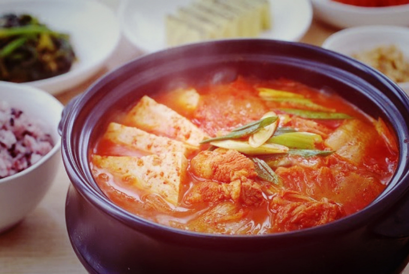 steaming iron bowl of kimchi soup